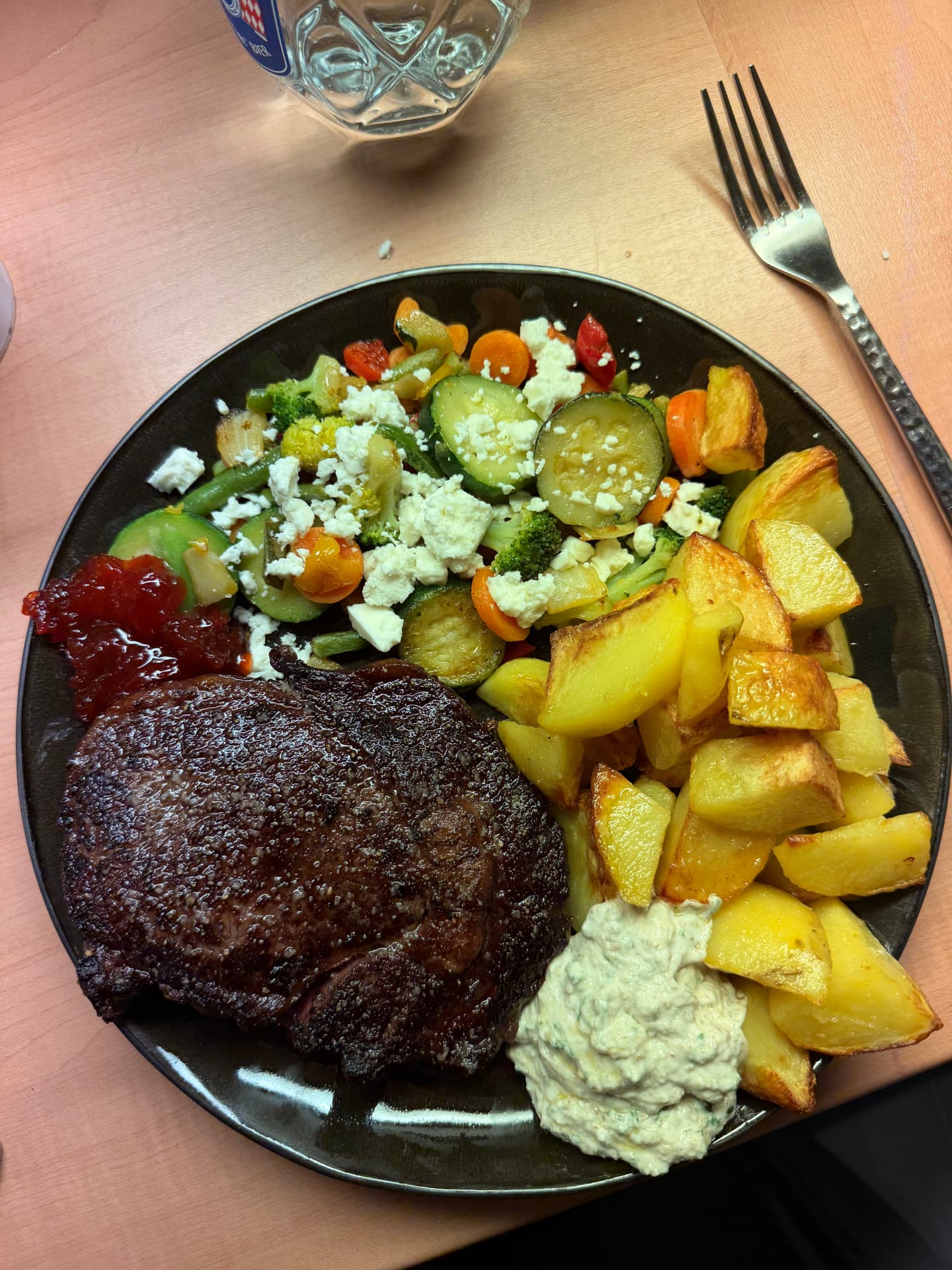 Rib-eye steak with roast potatoes, vegetables and sauces